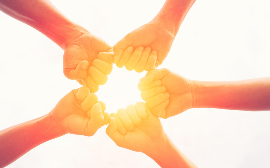 group of hands fist bumping in a circle